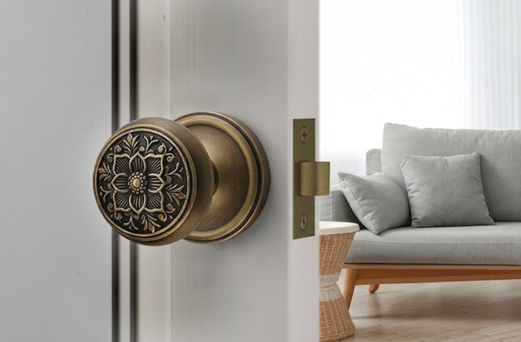 Antique brass floral door knob with round rosette installed on an off-white interior door