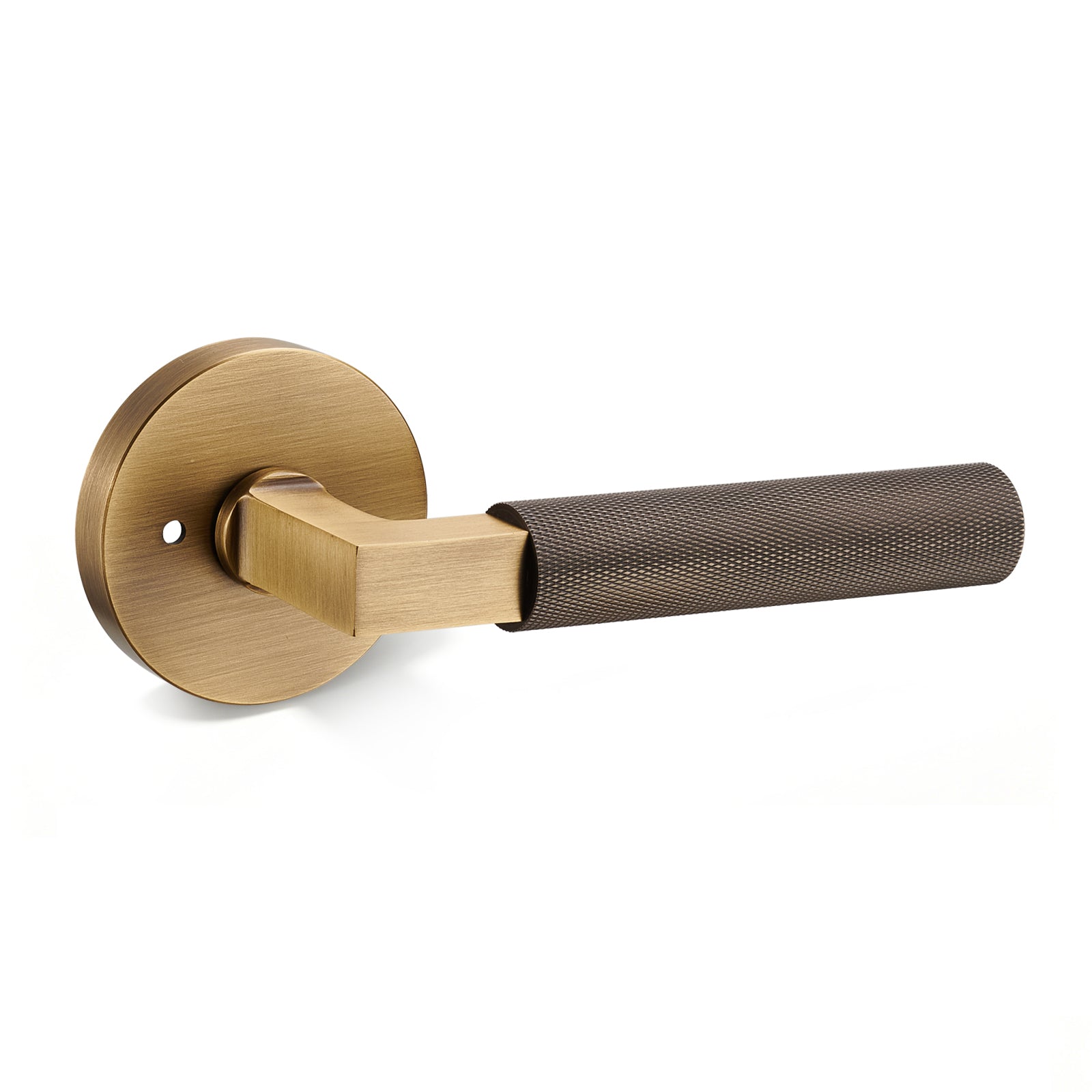 A single Flirabbit Antique Brushed Brass Knurled Linear Privacy Door Lever with its distinctive diamond-cut grip, on a white background.